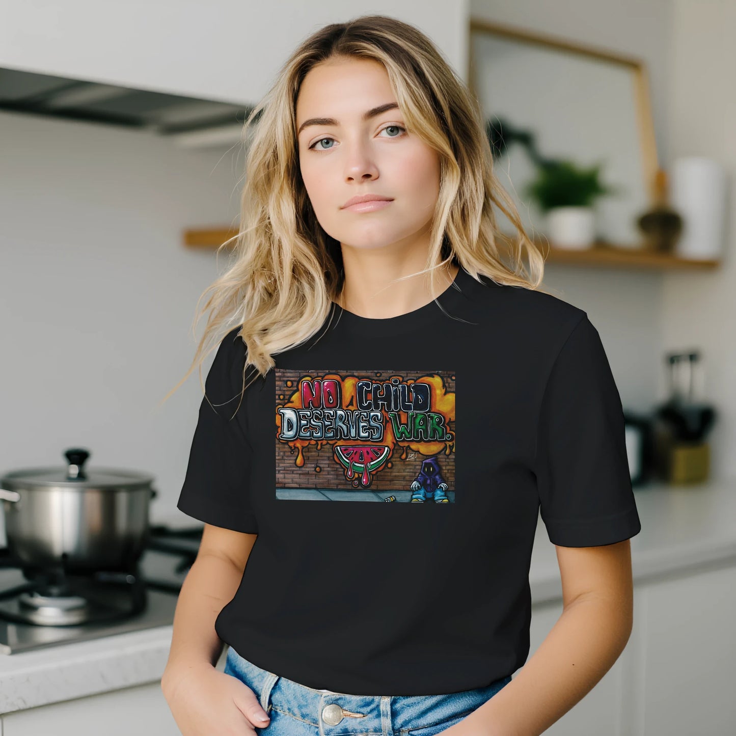 Person wearing a black t-shirt with a colorful graphic design in a kitchen setting