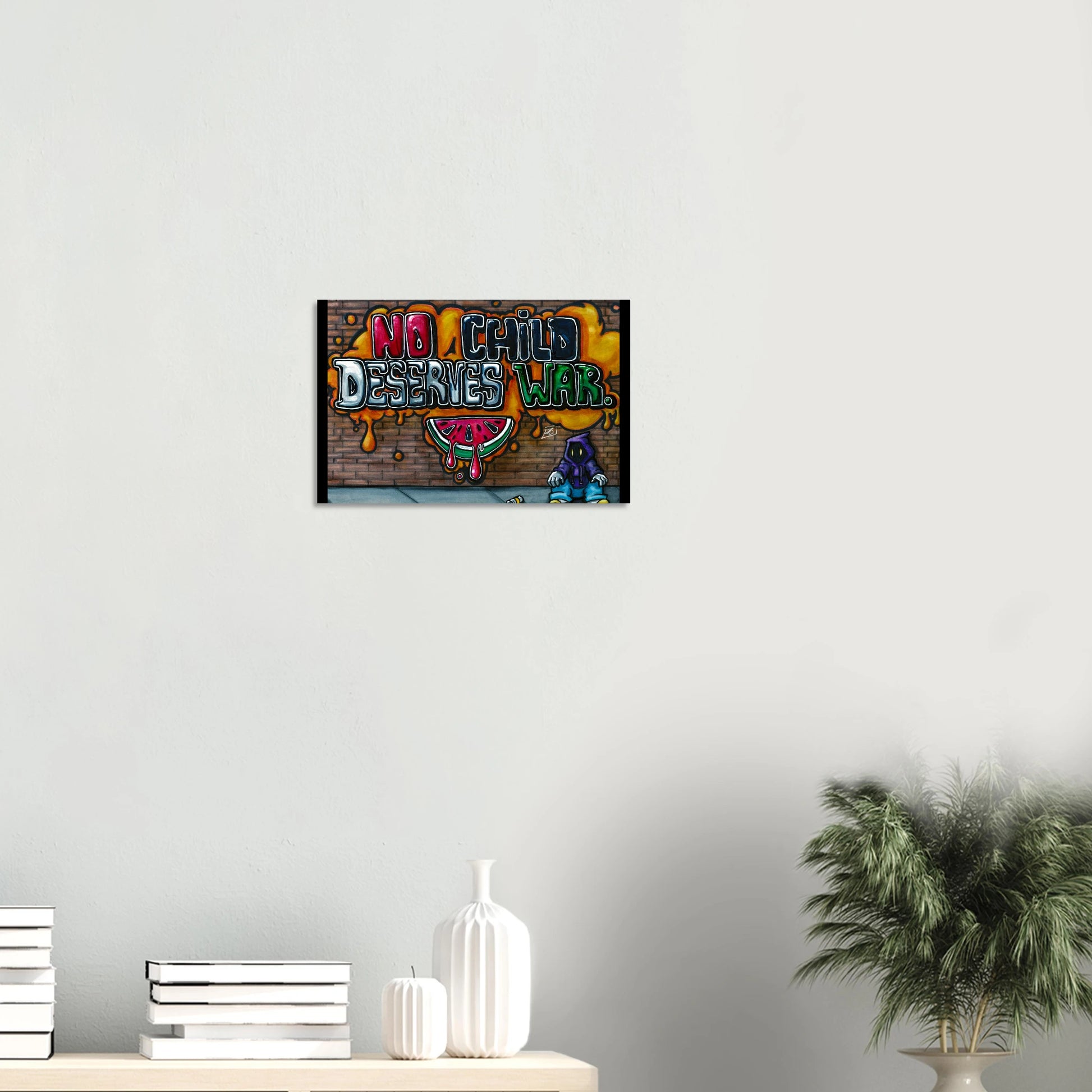 Framed artwork with 'No Child Deserves War' text on a wall above a table with decor items.